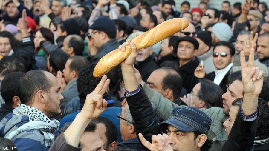 تونسي يرفع الخبز خلال مظاهرة في تونس العاصمة يوم 27-12-2010 احتجاجاً على استخدام الأمن القوة ضد المحتجين في سيدي بوزيد