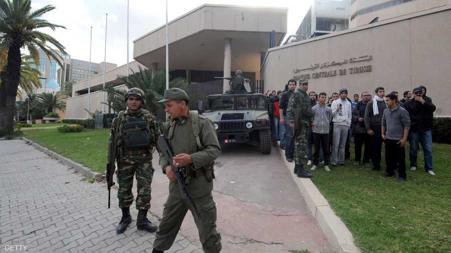 أفراد من الجيش التونسي يقومون بحماية المتظاهرين من قبل الحرس الرئاسي أمام البنك المركزي التونسي يوم 14 يناير 2011 قبيل رحيل بن علي