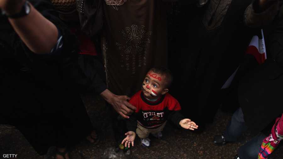 ألوان العلم على وجه طفل مصري وسط الحشود بميدان التحرير