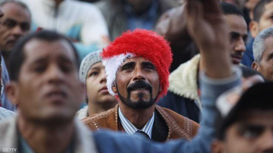 رجل يرتدي قبعة بألوان العلم المصري وسط المتظاهرين في ميدان التحرير