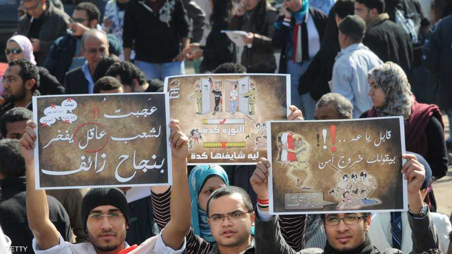 شباب يرفعون لافتات مناهضة للمجلس العسكري الحاكم