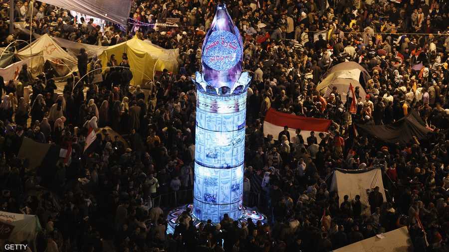 المتظاهرون يلتفون حول نصب تذكاري مؤقت أقاموه تمجيدا لشهداء الثورة