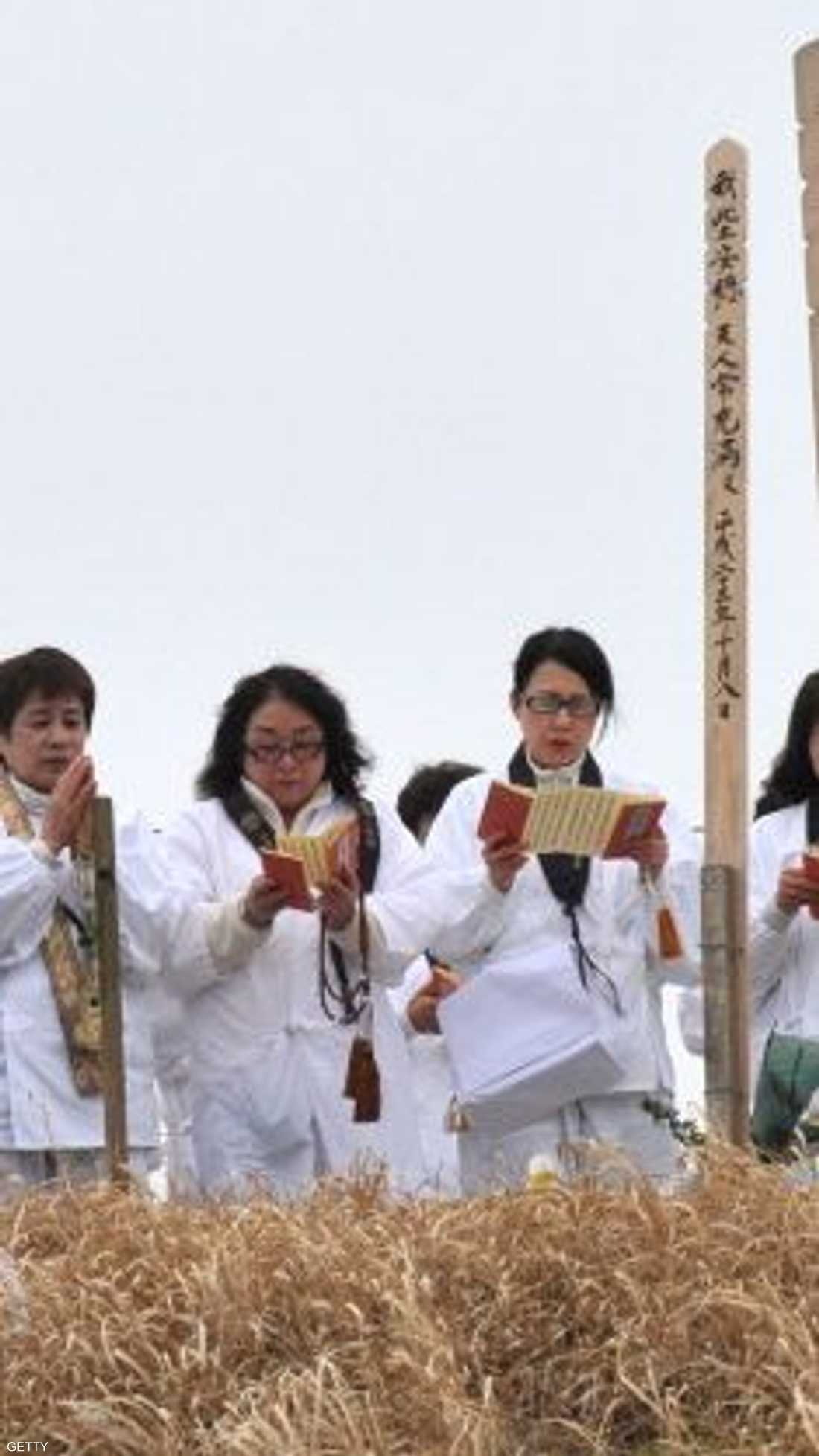 يتلون الصلوات على أرواح الضحايا أمام نصب تذكاري.