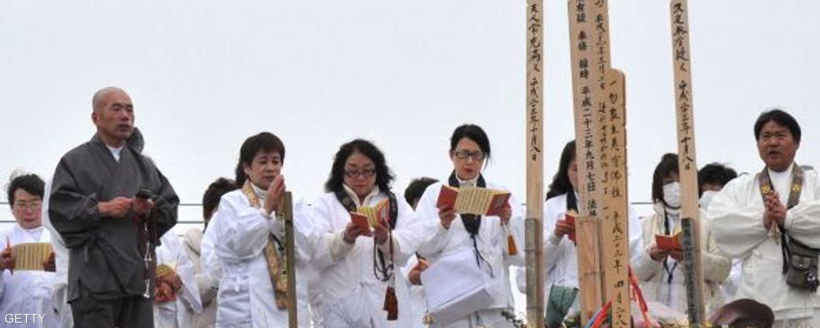 يتلون الصلوات على أرواح الضحايا أمام نصب تذكاري.