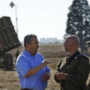 وزير الدفاع الإسرائيلي إيهود باراك يقف بالقرب من منظومة للقبة الحديدية