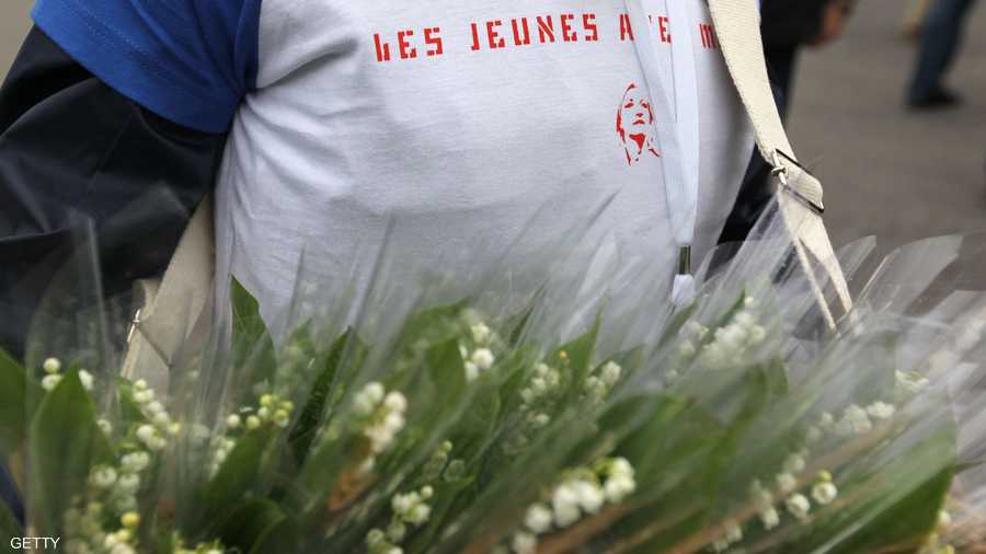 أحد مناصري حزب الجبهة الوطنية اليميني الفرنسي يبيع زهور عيد العمال "زنبق الوادي" قرب القصر الملكي 