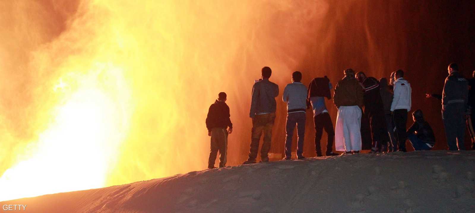 مصريون ينظرون إلى حريق شب في أنبوب الغاز المصري الواصل إلى إسرائيل في فبراير