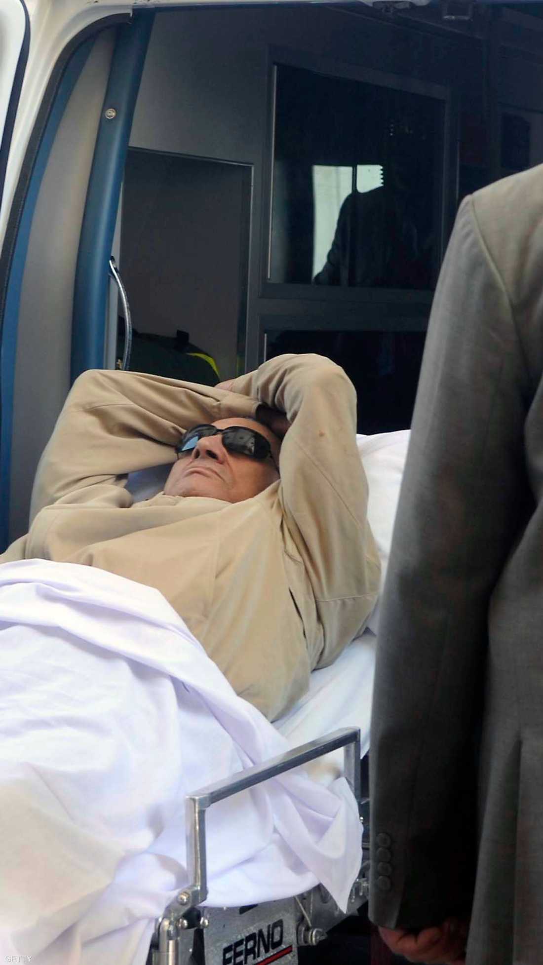 الرئيس المصري السابق حسني مبارك أثناء خروجه من سيارة الإسعاف لدخول قاعة المحكمة