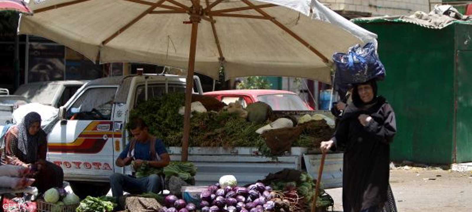 مصرية تسير بأحد الأسواق الشعبية
