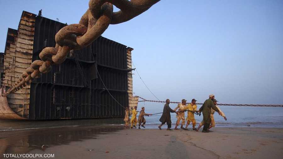 عمال في كراتشي يحاولون سحب هذه السفينة التي أحيلت إلى التقاعد