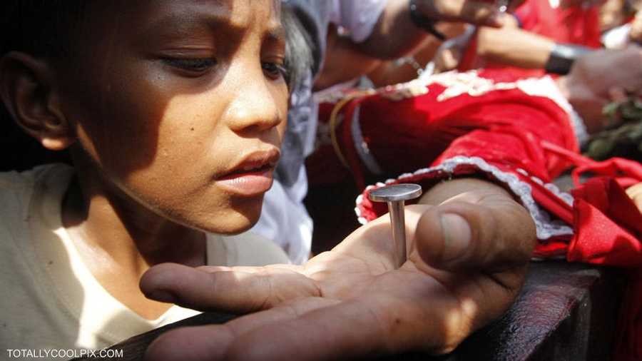 يتأمل هذا الطفل المسمار الذي صلب فيه أحدهم لإحياء ما عاناه المسيح