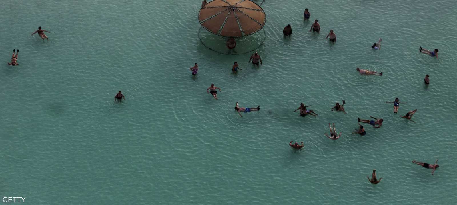 سياح يستحمون على أحد شواطئ البحر الميت في الأردن
