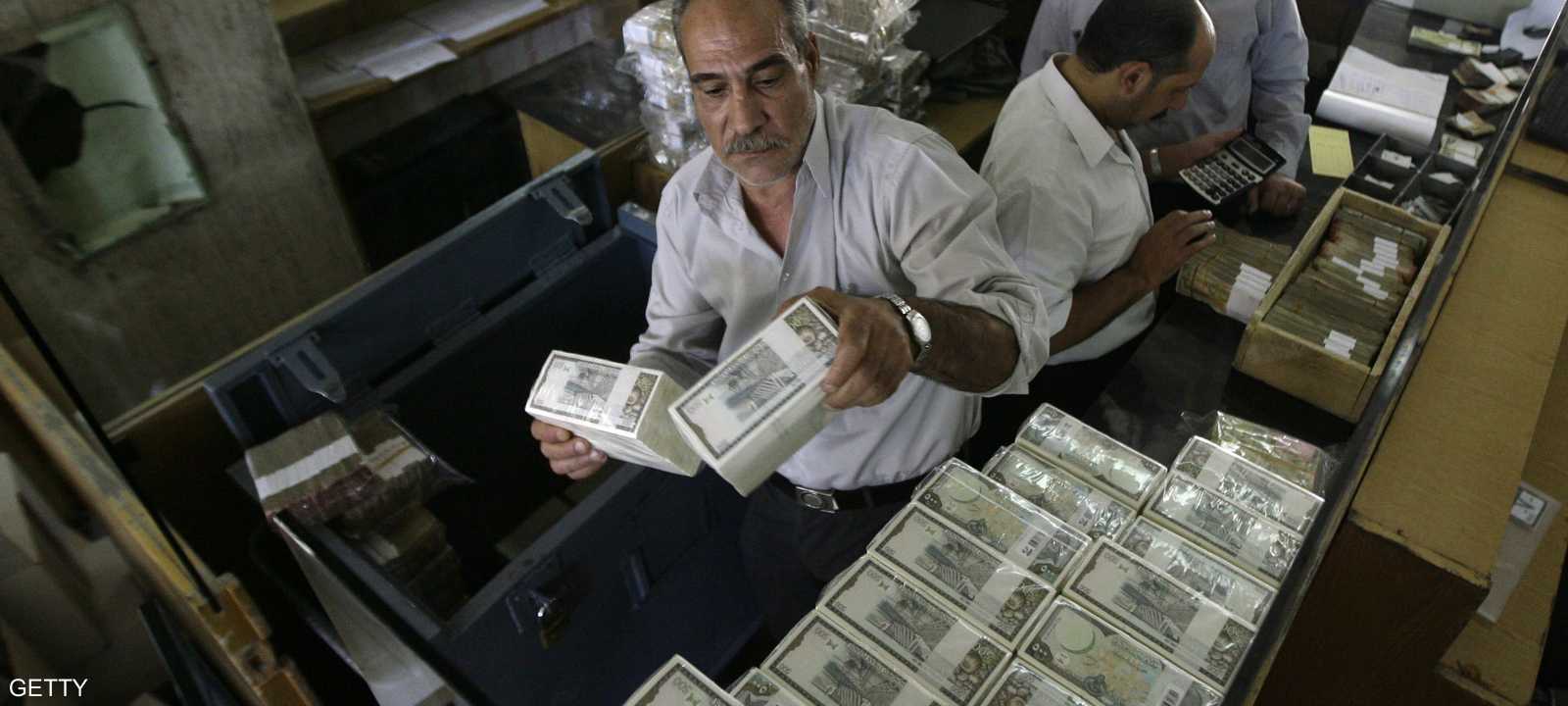 موظفون في البنك المركزي السوري في دمشق يرتبون رزما من العملية المحلية الليرة.