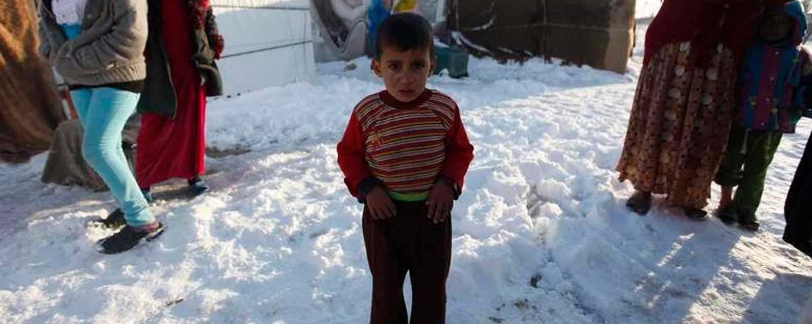 رد فعل طفل سوري لاجئ من مدينة الرقة على الثلوج المتراكمة في مخيم للاجئين في لبنان 