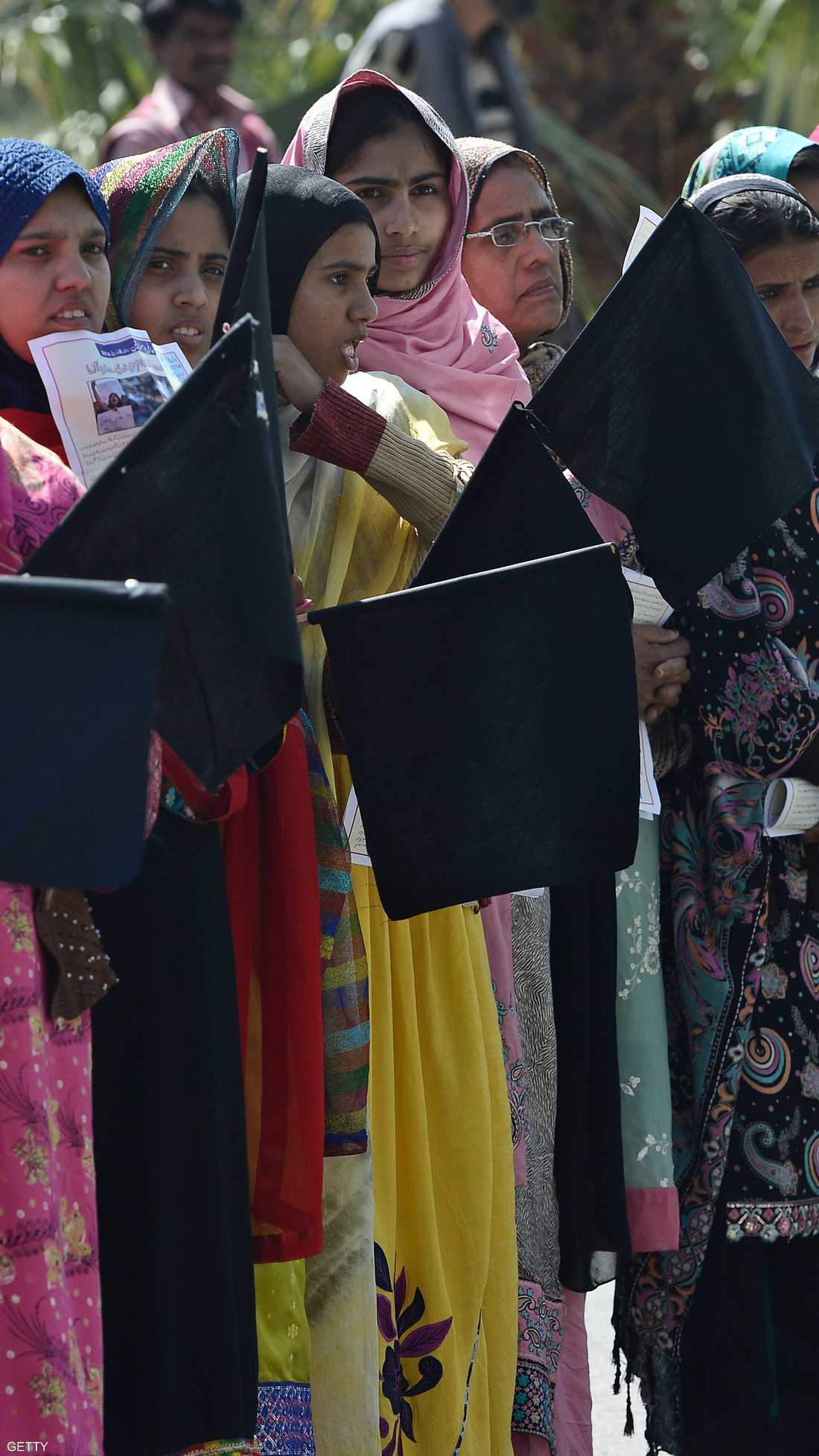 ناشطات باكستانيات يحملن أعلام سوداء احتجاجا على أوضاع المرأة أثناء مشاركتهن في مسيرة بإسلام آباد.