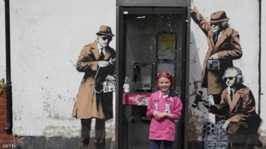 فتاة صغيرة تستعد لالتقاط صورة للذكرى مع جدارية بانكسي الجديدة