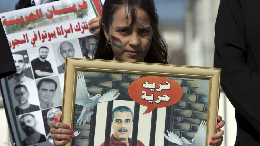 طفلة فلسطينية تحمل صورة أحد الأسرى المعتقلين في السجون الإسرائيلية.