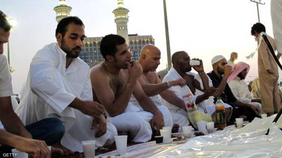 معتمرون يكسرون صيامهم في رمضان في ساحات الحرم المكي الخارجية.