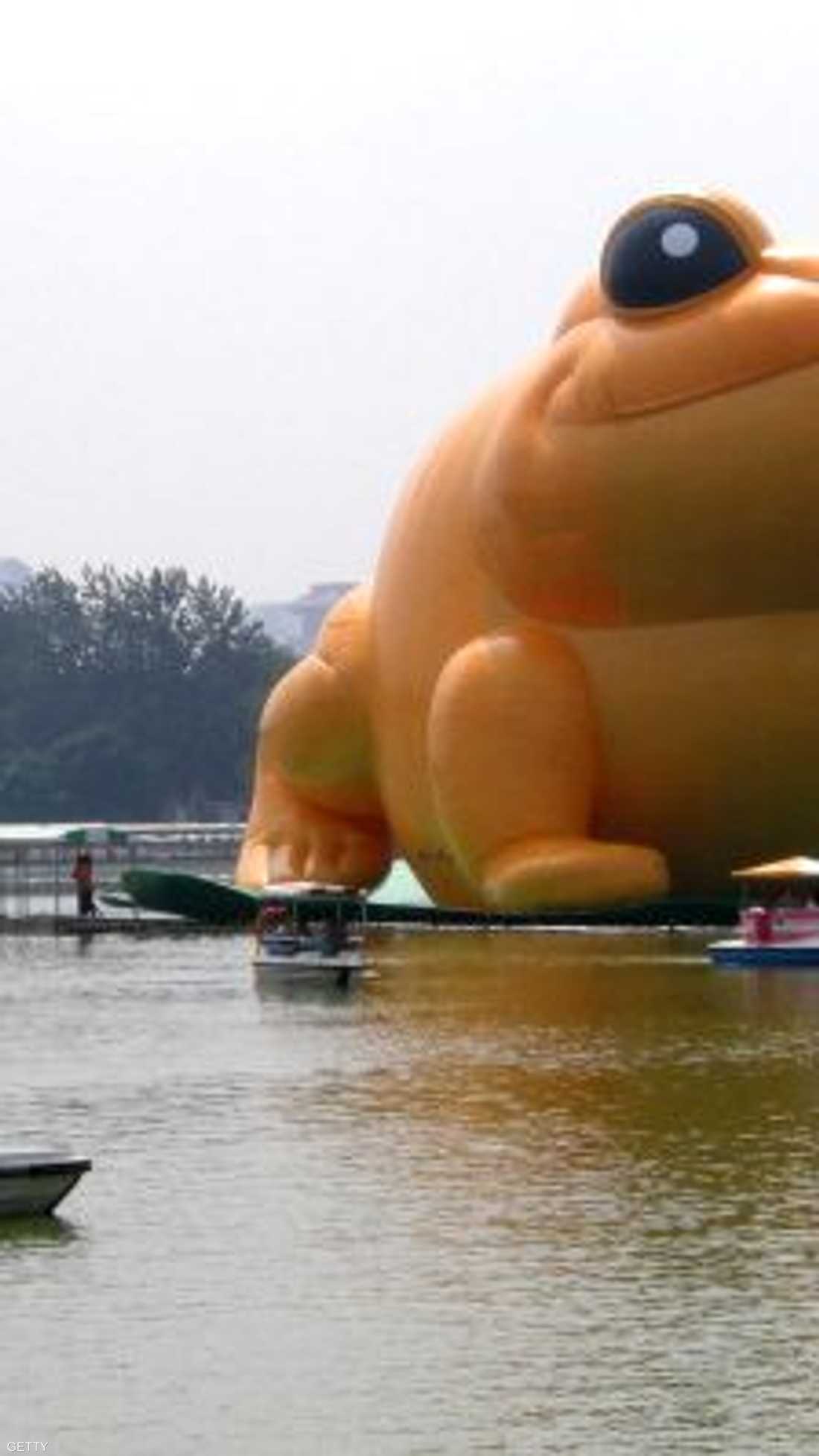 مجسم عملاق لضفدع عائم، على شاطئ بحيرة، بحديقة يوييوانتان، في العاصمة بكين