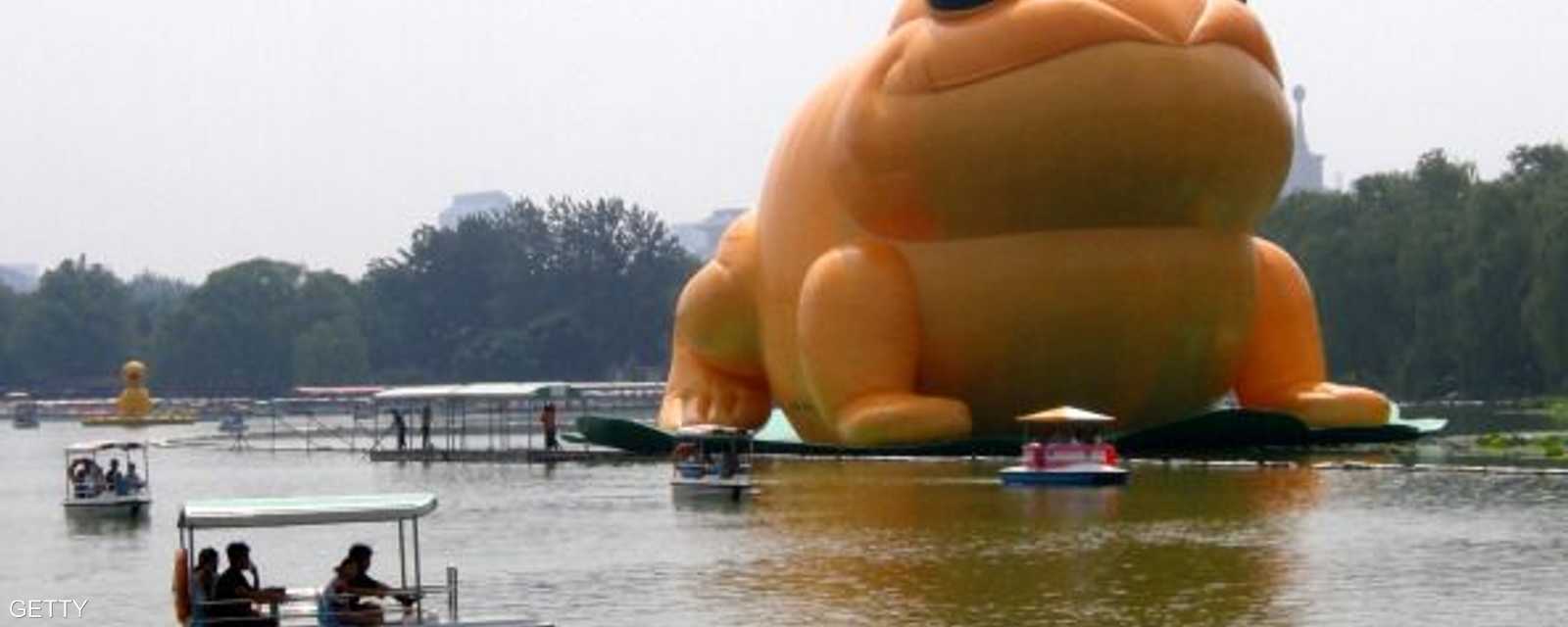 مجسم عملاق لضفدع عائم، على شاطئ بحيرة، بحديقة يوييوانتان، في العاصمة بكين