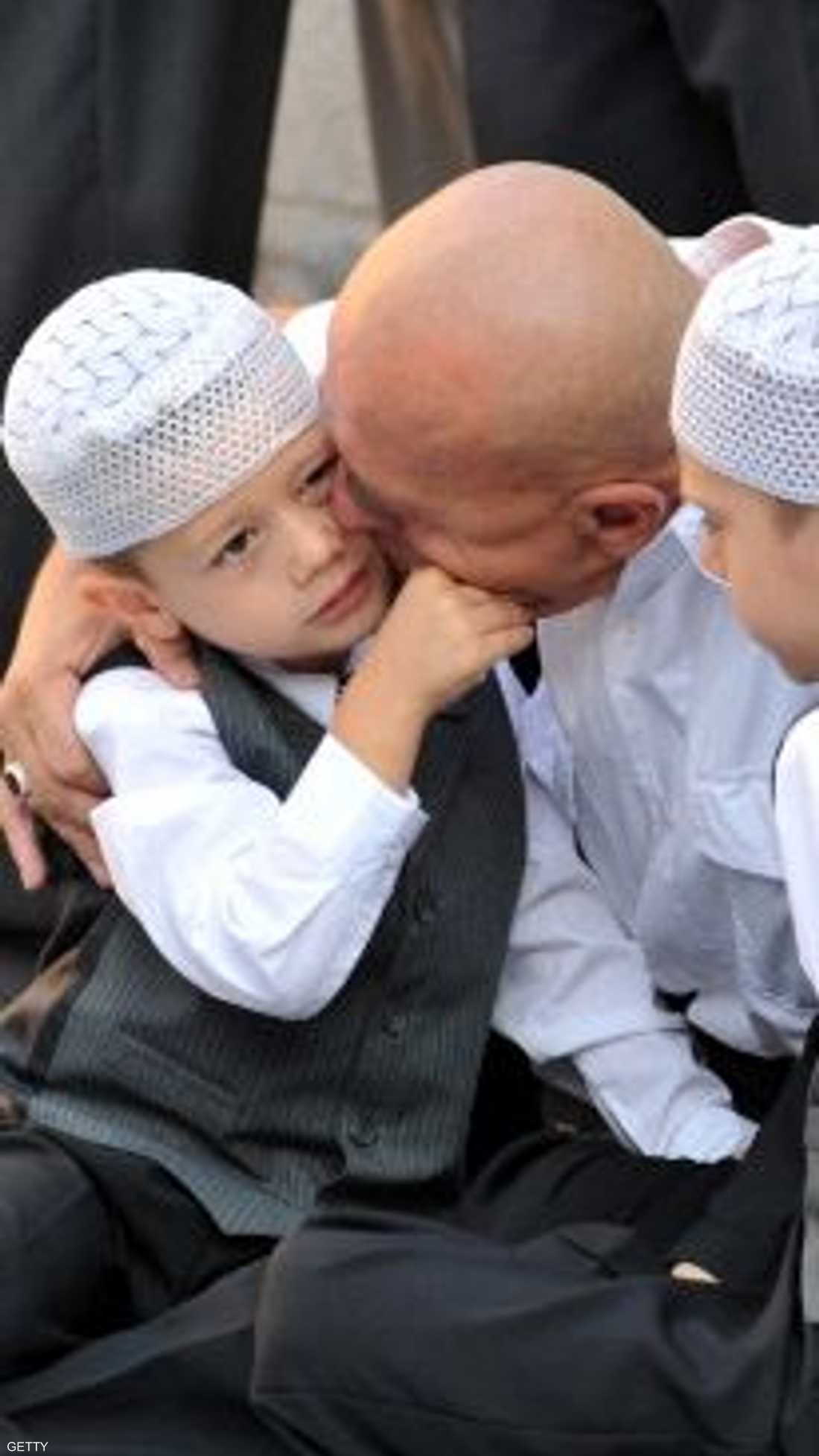 رجل بوسني سعيد بحضور ولديه معه إلى المسجد لأداء صلاة المغرب
