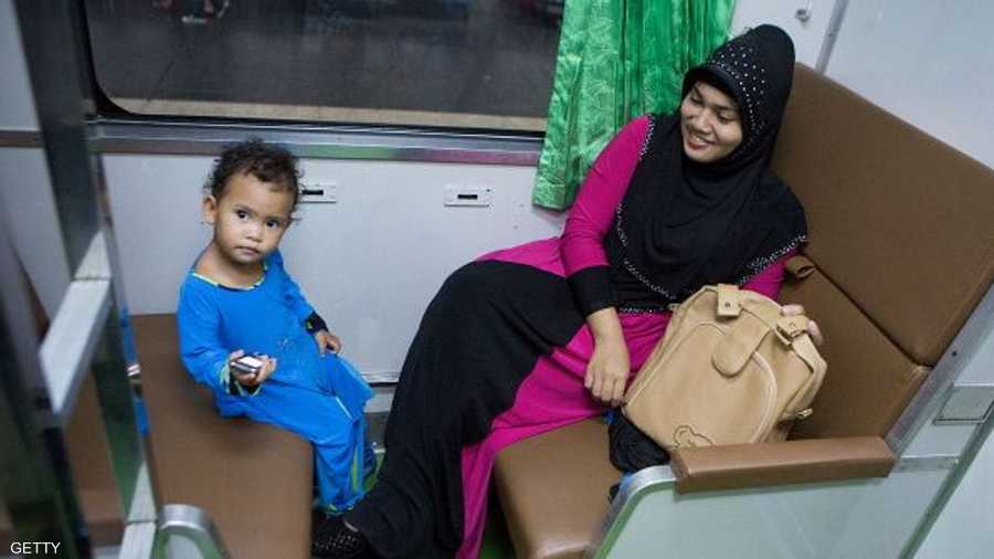 أم مسلمة مع طفلتها في عربة السيدات