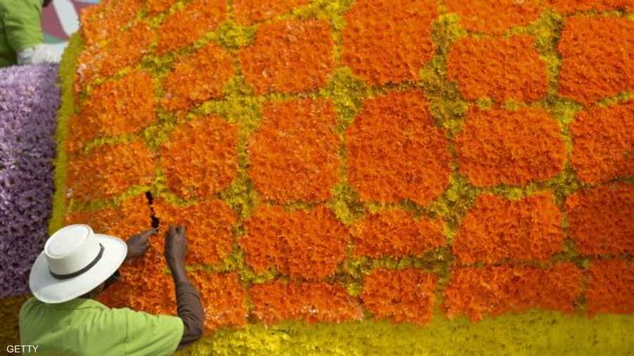 فنان كولومبي يعمل على أحد المجسمات من الزهور