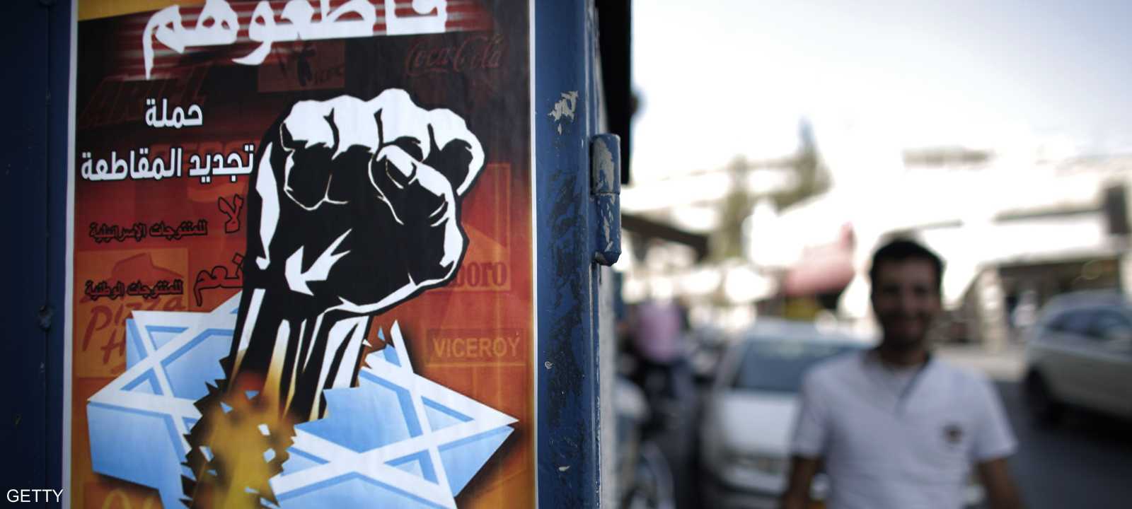 نشطاء فلسطينيون يوزعون ملصقات تحذر من أن شراء منتجات إسرائيلية يسهم بتمويل الجيش الإسرائيلي 