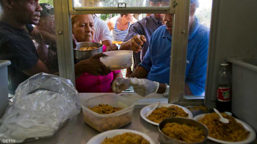 مواطنون يصطفون أمام مطعم في الدومنيكان لتناول وجبة تقليدية من الأرز والفاصوليا.