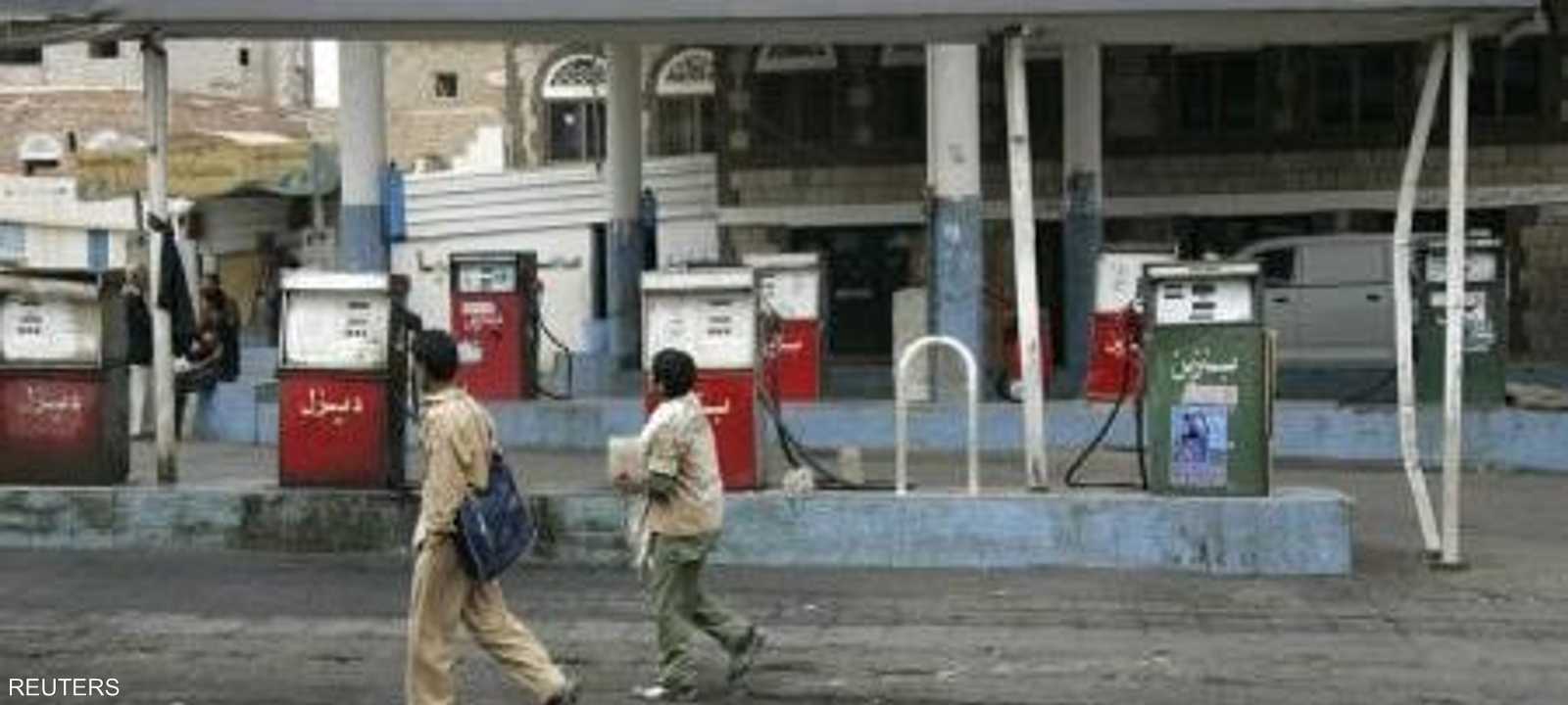 طفلان يمران أمام محطة محروقات في صنعاء