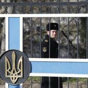 أحد رجال البحرية الروسية خلف بوابة تحمل شعار أوكرانيا في قاعدة بحرية في سيفاستوبول بالقرم