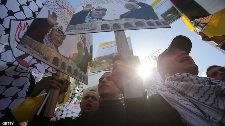 فلسطينيون يرفعون صور الرئيس الفلسطيني الراحل ياسر عرفات في الذكرى العاشرة لرحيله
