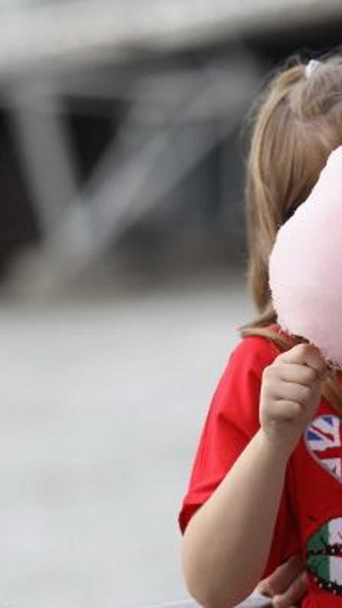 قطعة من الحلوى الشهيرة تبدو أكبر من وجه الطفلة التي تحملها