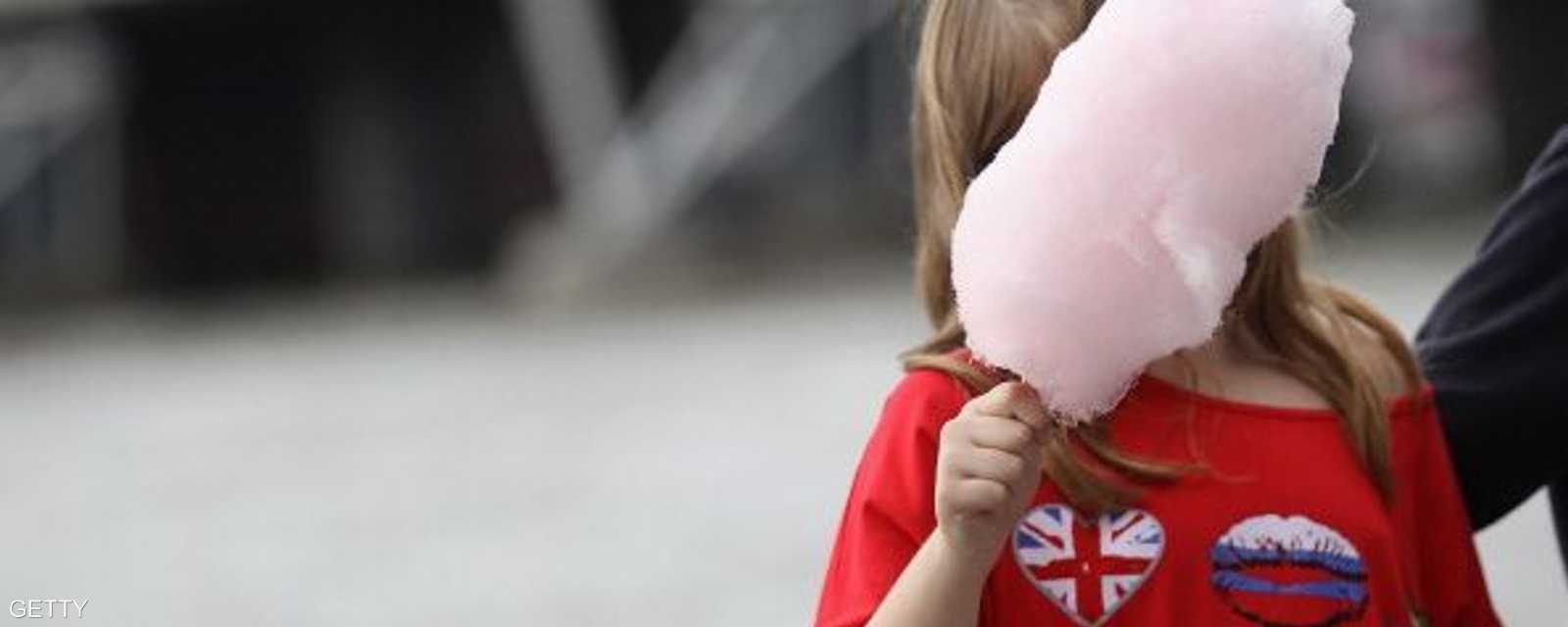 قطعة من الحلوى الشهيرة تبدو أكبر من وجه الطفلة التي تحملها