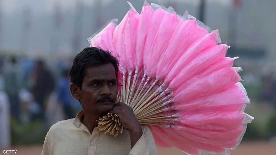 وبائع هندي يحمل الحلوى المصنوعة من الماء والسكر