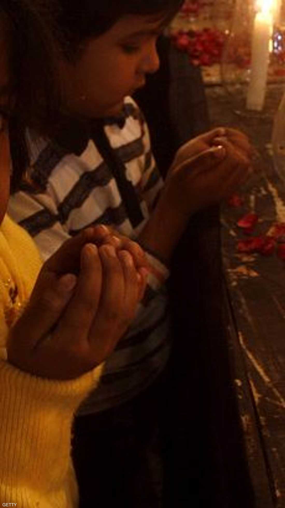 طفلة باكستانية تدعو لذويها من ضحايا هجوم بيشاور خلال وقفة تأبين بالشموع في كراتشي