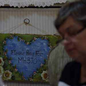 زوجة المشرف على طائرة الخطوط الجوية الماليزية MH370 تصلي مع عائلتها في مكان إقامتهم في كوالالمبور - سبتمبر 2014.