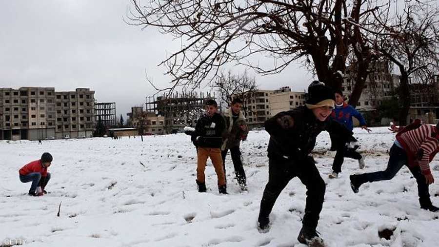 أطفال سوريون يلهون بالثلوج