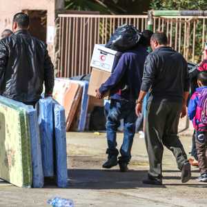 نازحون ليبيون يحملون مساعدات الهلال الأحمر