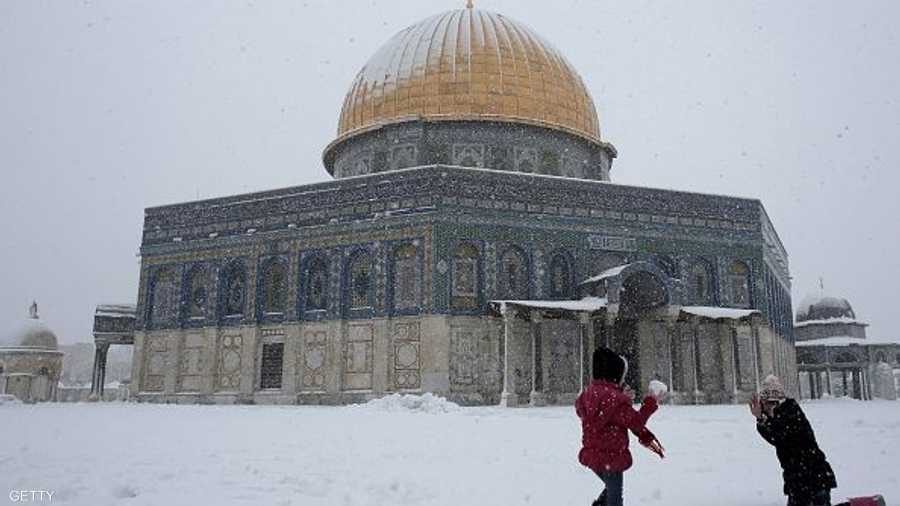أطفال فلسطينيون يلعبون بالثلوج أمام قبة الصخرة