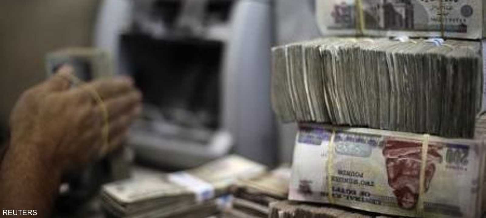 موظف يعد عملات ورقية من الجنيه المصري في مكتب لتغيير العملات بالقاهرة