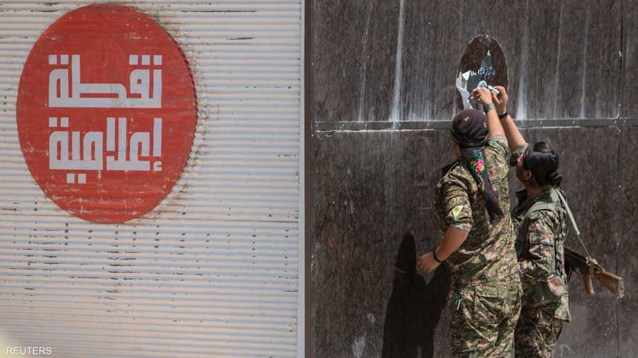 قوات حماية الشعب الكردي أزالت ملصقات داعش من جدران مباني تل أبيض