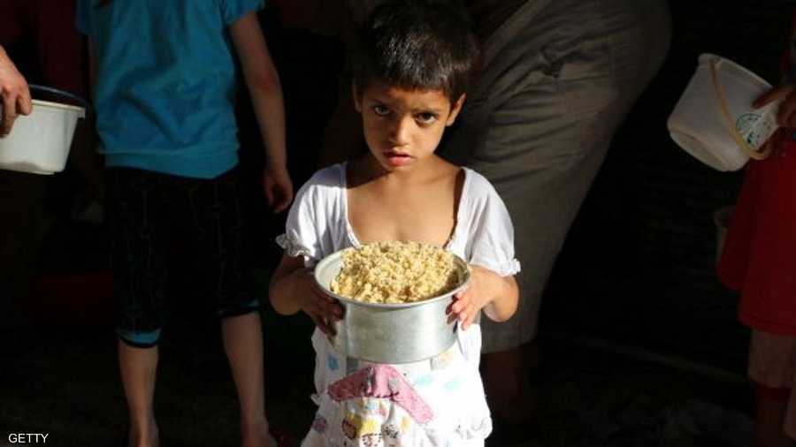 وطفل سوري سعيد بالحصول على وجبة إفطار لأهله في حلب