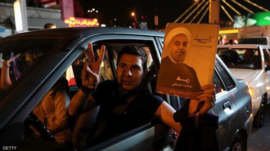 إيراني يرفع صورة الرئيس روحاني