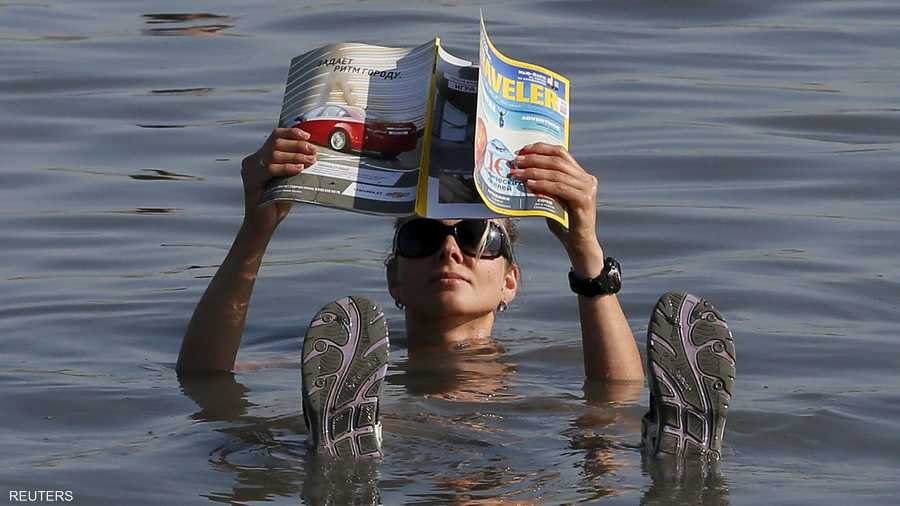 تقرأ صحيفة وهي تطفو فوق الماء في بحيرة طوس المالحة