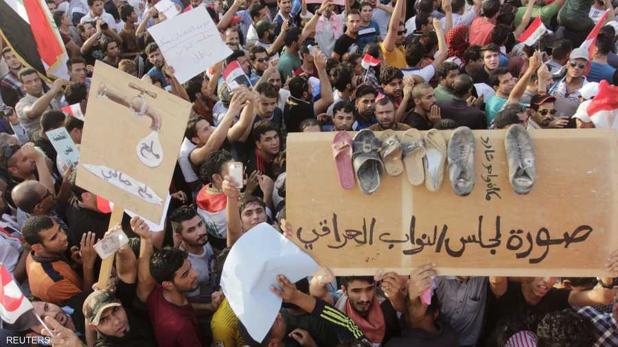 المتظاهرون يحملون لافتات ضد مجلس النواب العراقي 