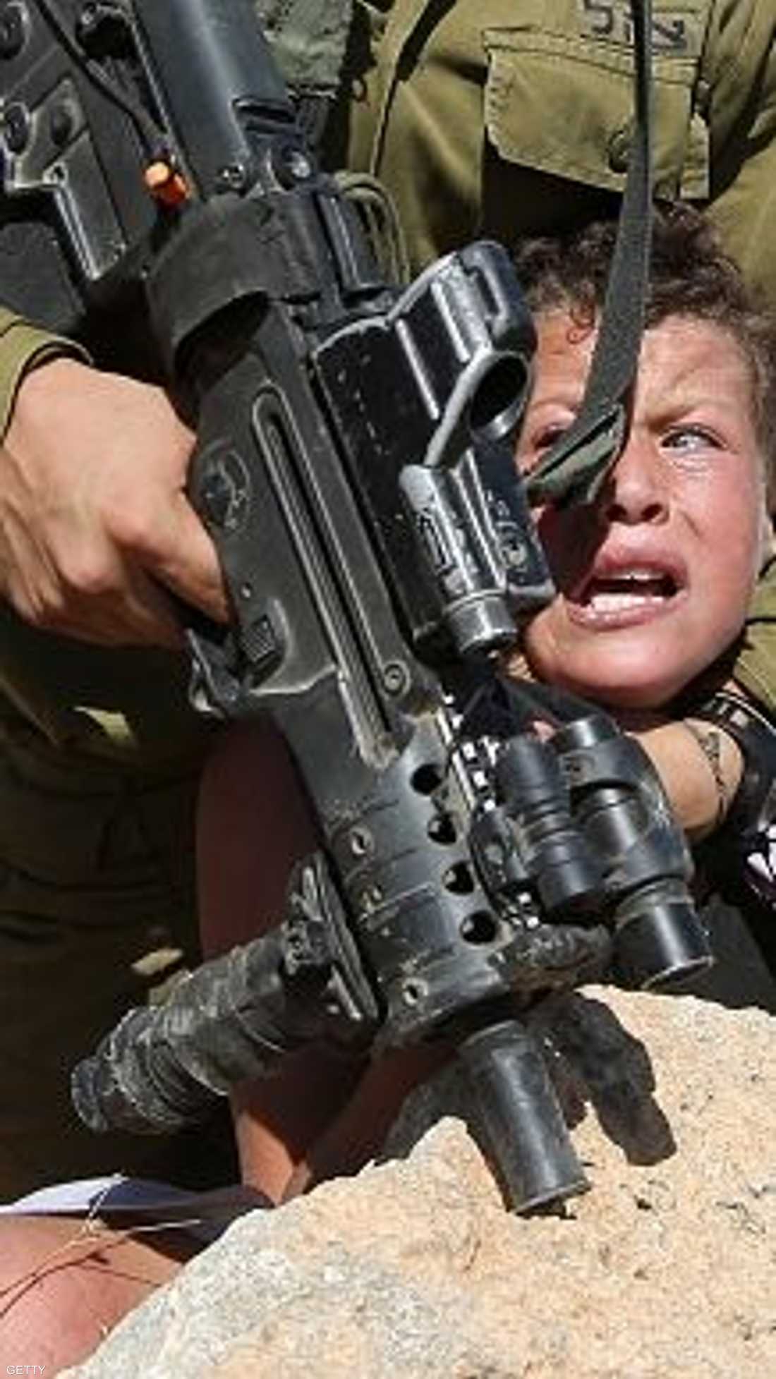 الجندي الإسرائيلي يمارس جبروته على طفل فلسطيني بيد مكسورة