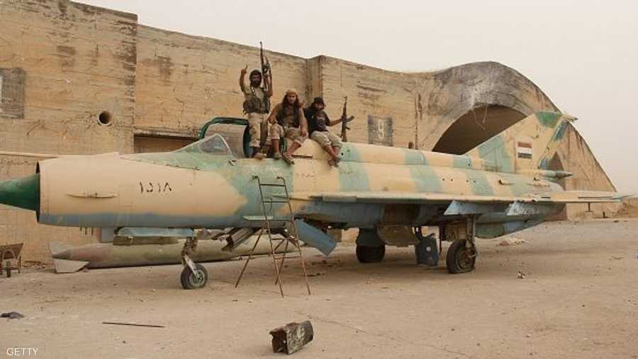 مسلحو المعارضة السورية يعتلون إحدى الطائرات المقاتلة في مطار أبو الظهور