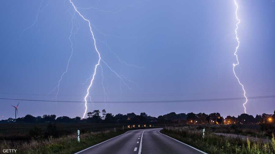 البرق يلمع نهارا فوق إحدى الطرق في ألمانيا.