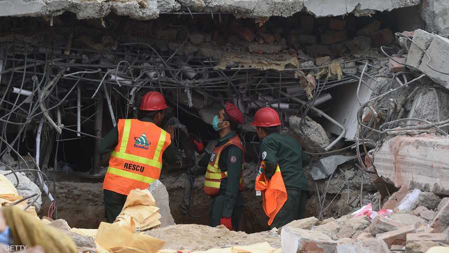رجال الإنقاذ يبحثون عن خيط حياة بين طبقات المبنى بعد انهياره.